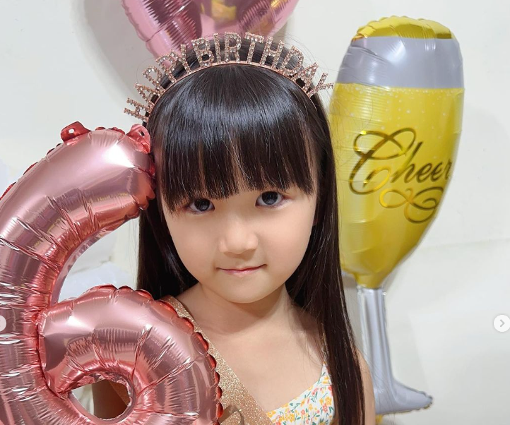 福原愛とジャン ホンジェの長女アイラちゃんがHappy Birthdayのカチューシャをしてこちらに微笑む写真